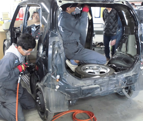 ボディ損傷を修復する車体整備士